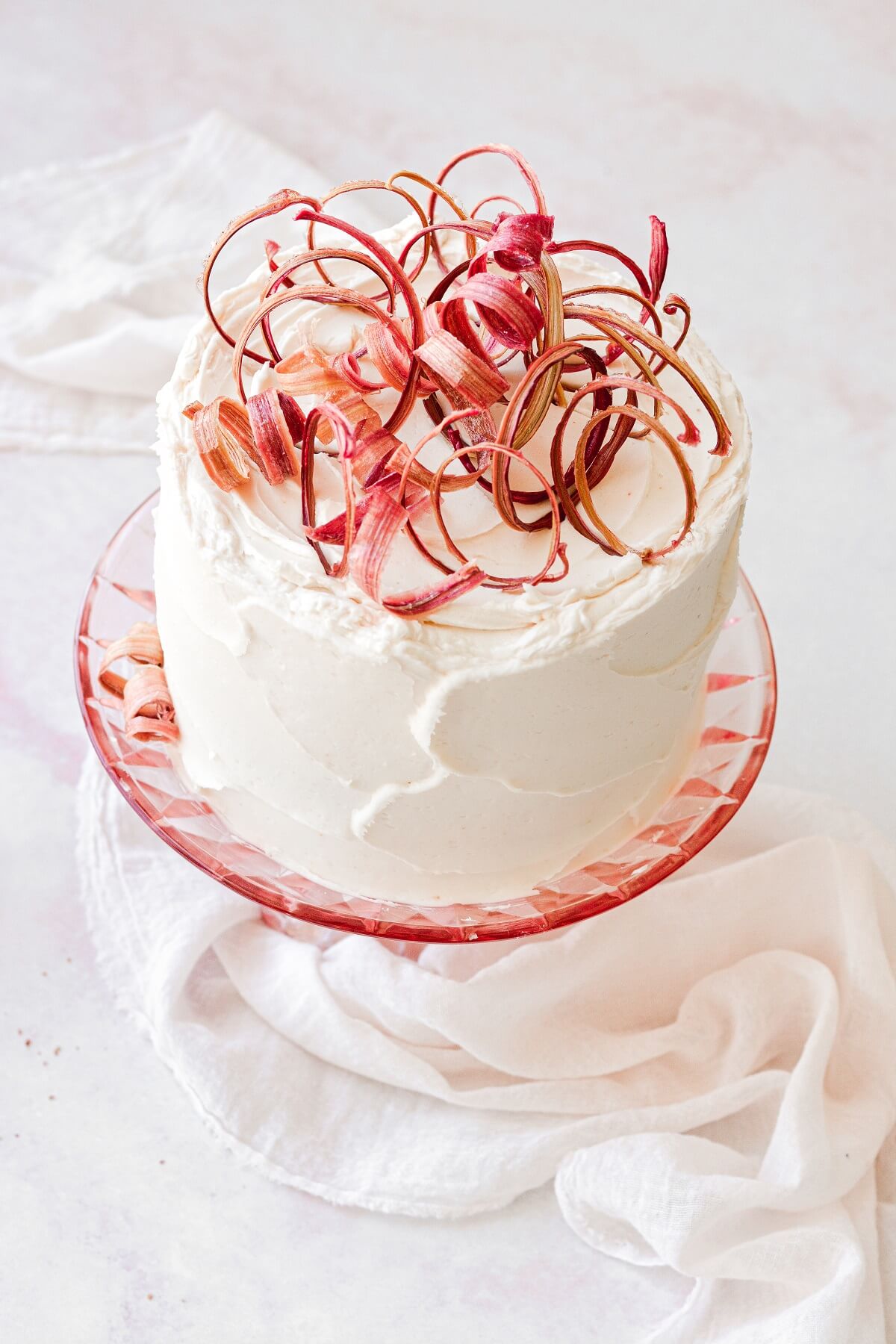 Vanilla rhubarb layer cake topped with candied rhubarb curls.