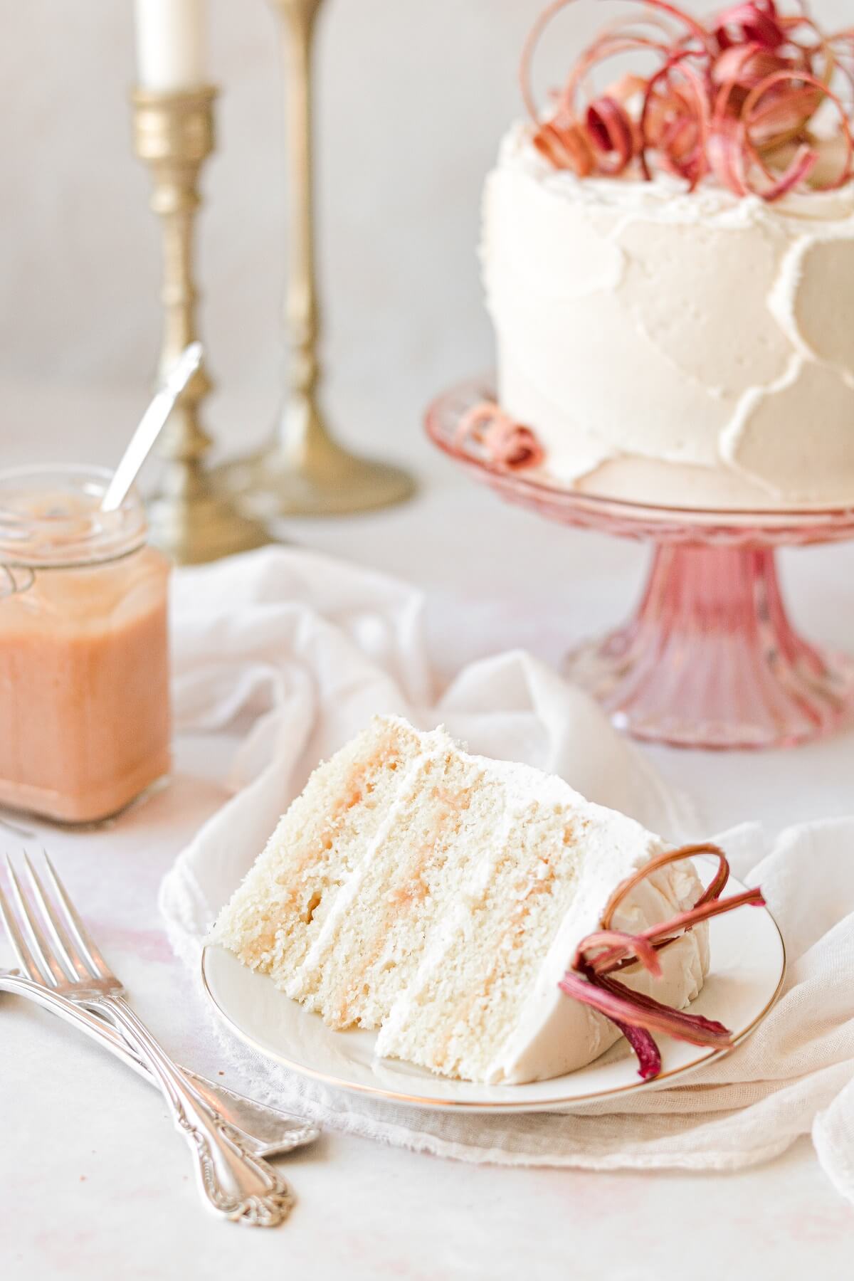 A slice of vanilla rhubarb layer cake topped with candied rhubarb curls.