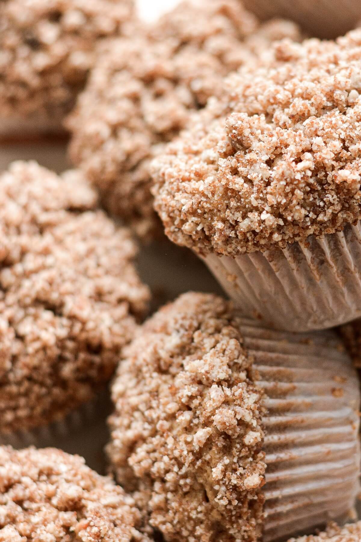 Apple crumb muffins, piled on a plate.