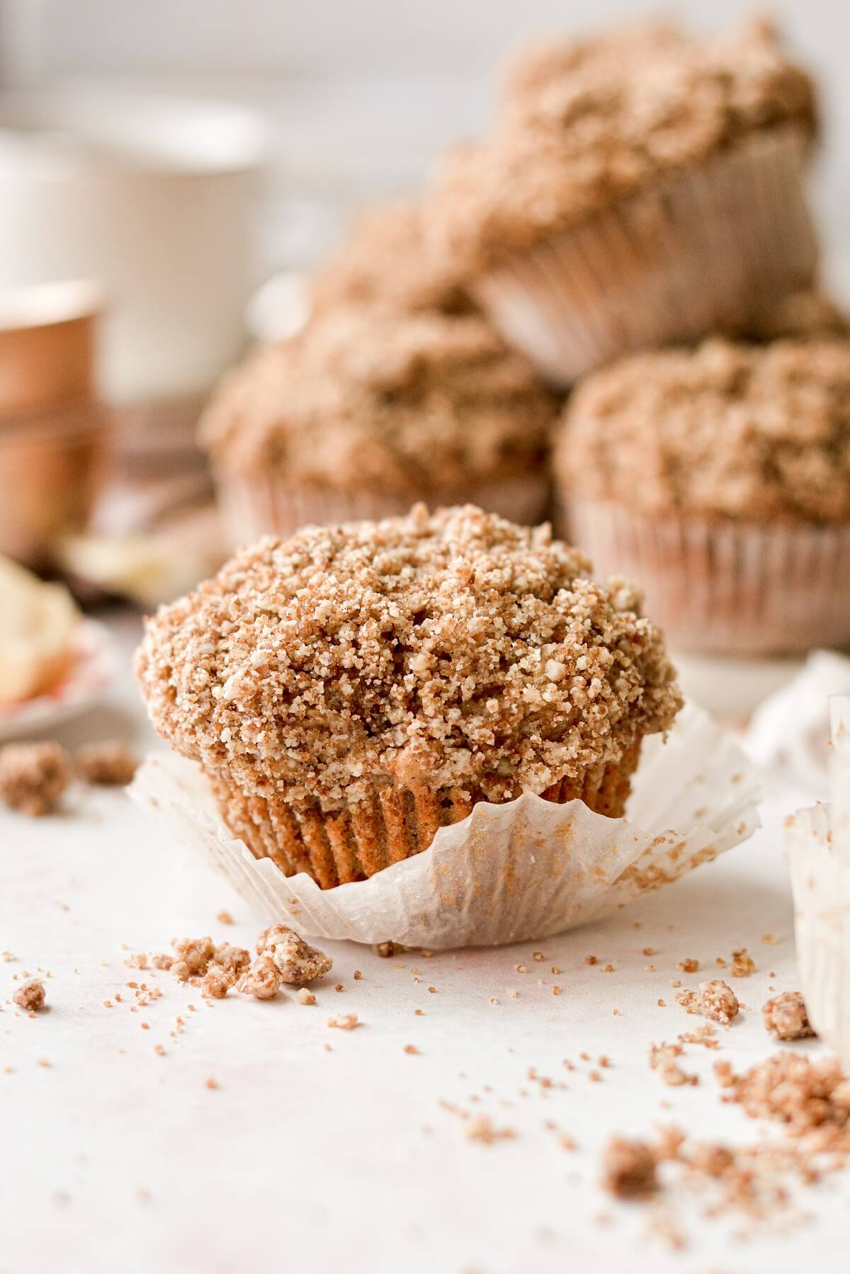 An apple spice muffin with crumb topping, with the wrapper pulled back.