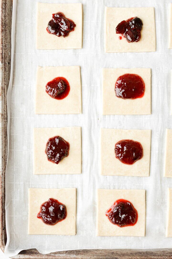 Squares of pie dough, topped with cherry jam.
