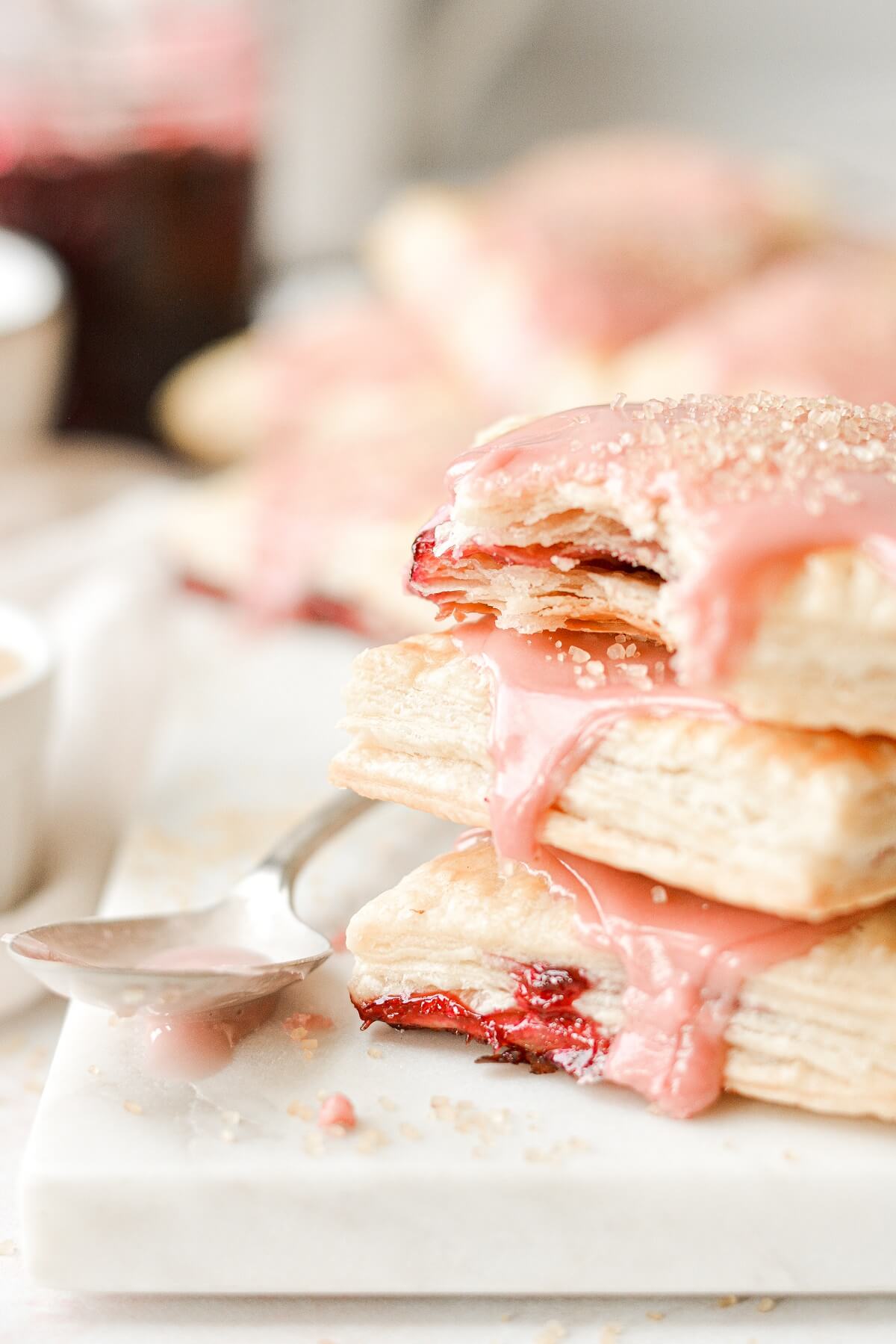 A stack of homemade cherry pop tarts, one with a bite taken.