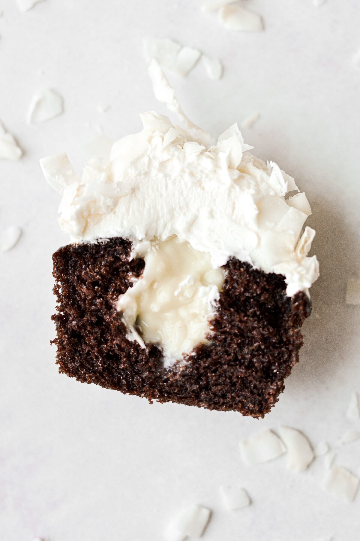 A chocolate coconut cupcake cut in half, filled with coconut custard.