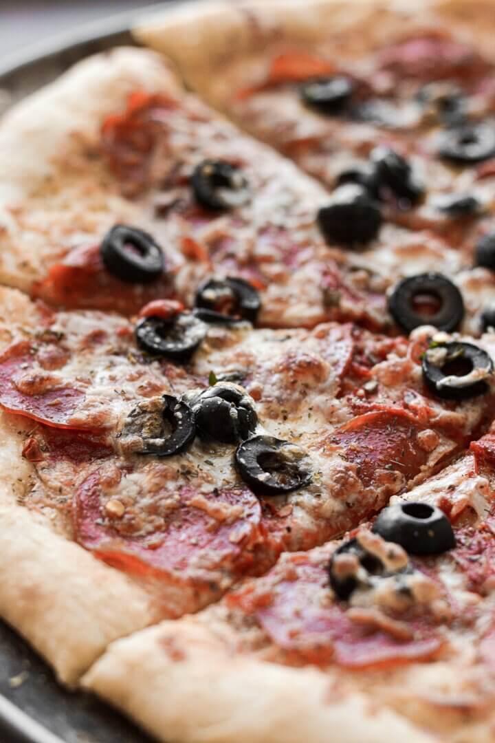 Homemade pizza, with pepperoni and black olives.