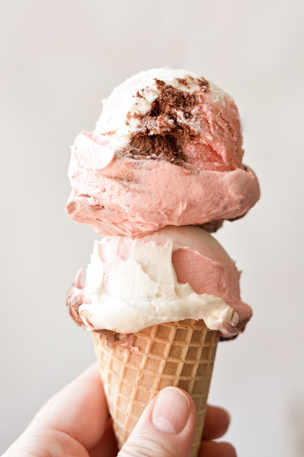 Neapolitan buttercream scooped like ice cream in an ice cream cone.