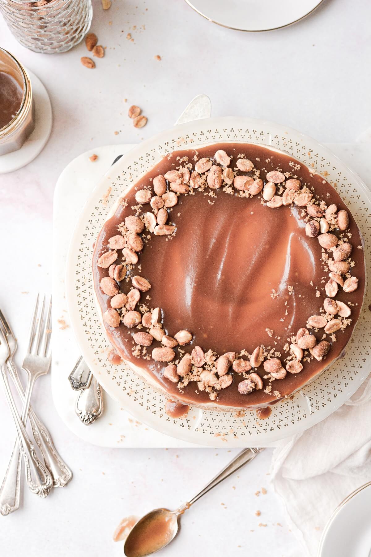 Peanut butter cheesecake with caramel sauce and peanuts.