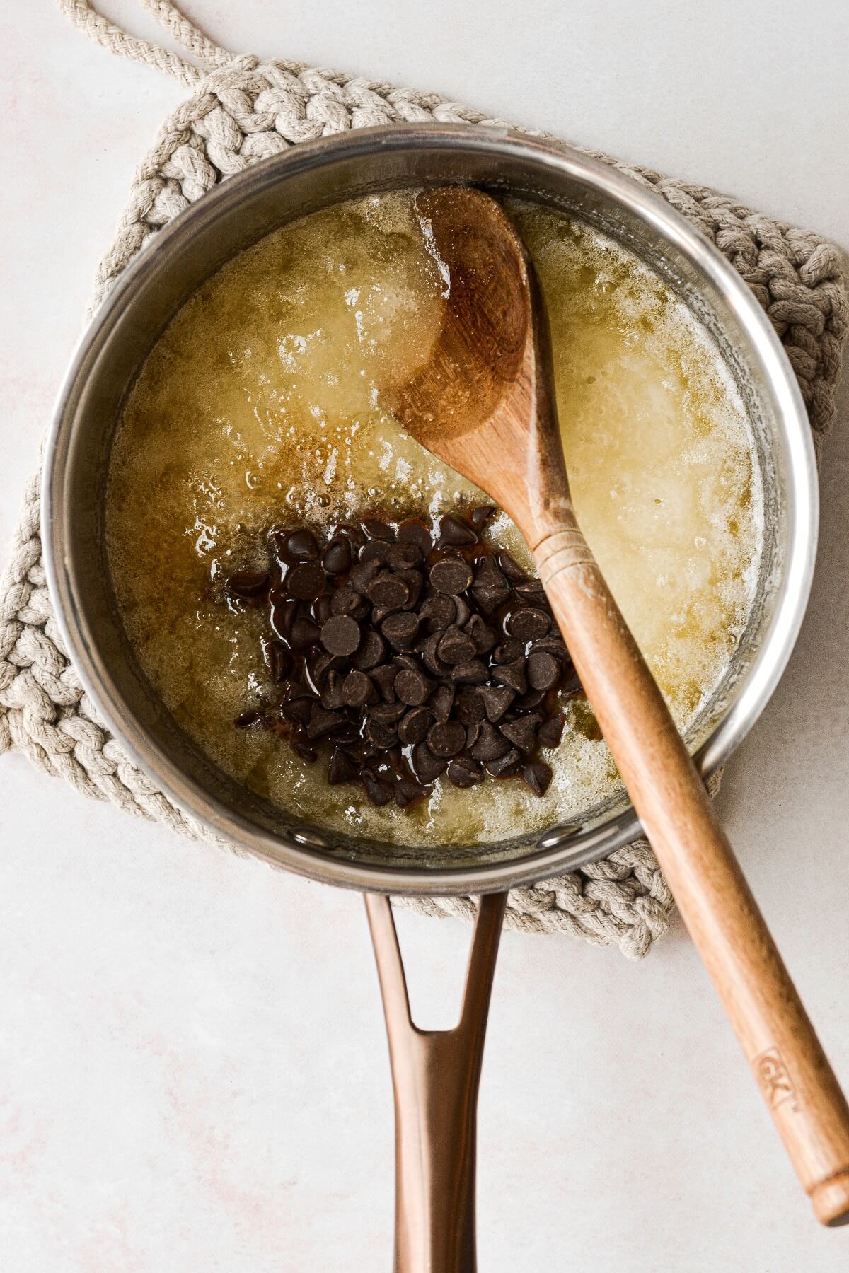 Stirring in chocolate chips to sugar and butter.