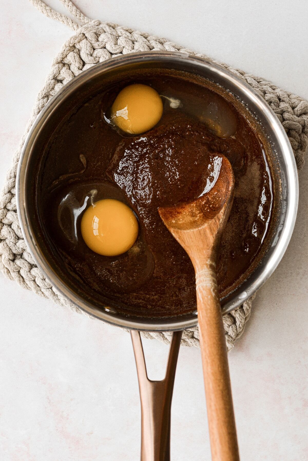 Stirring eggs into brownie batter.