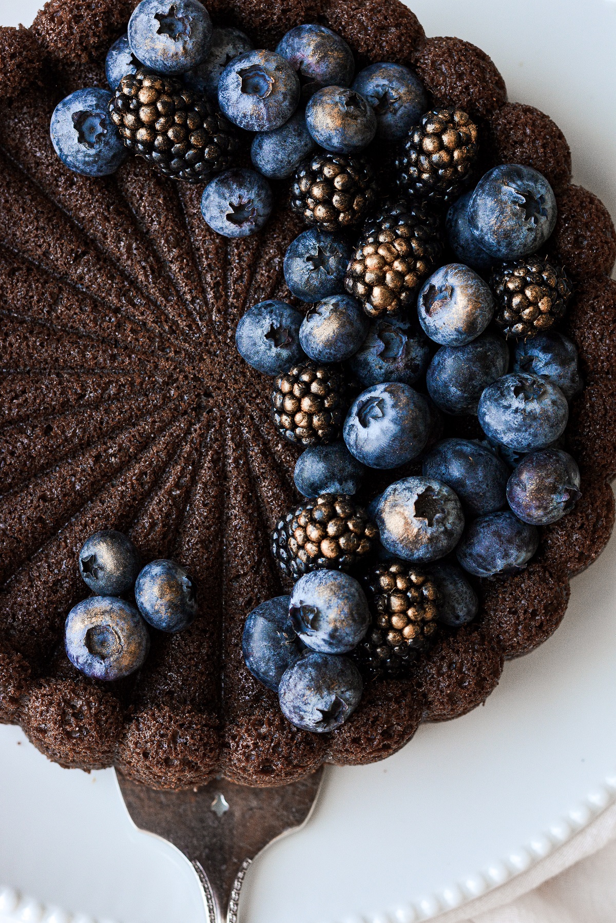 Chocolate Charlotte cake topped with blueberries and blackberries.