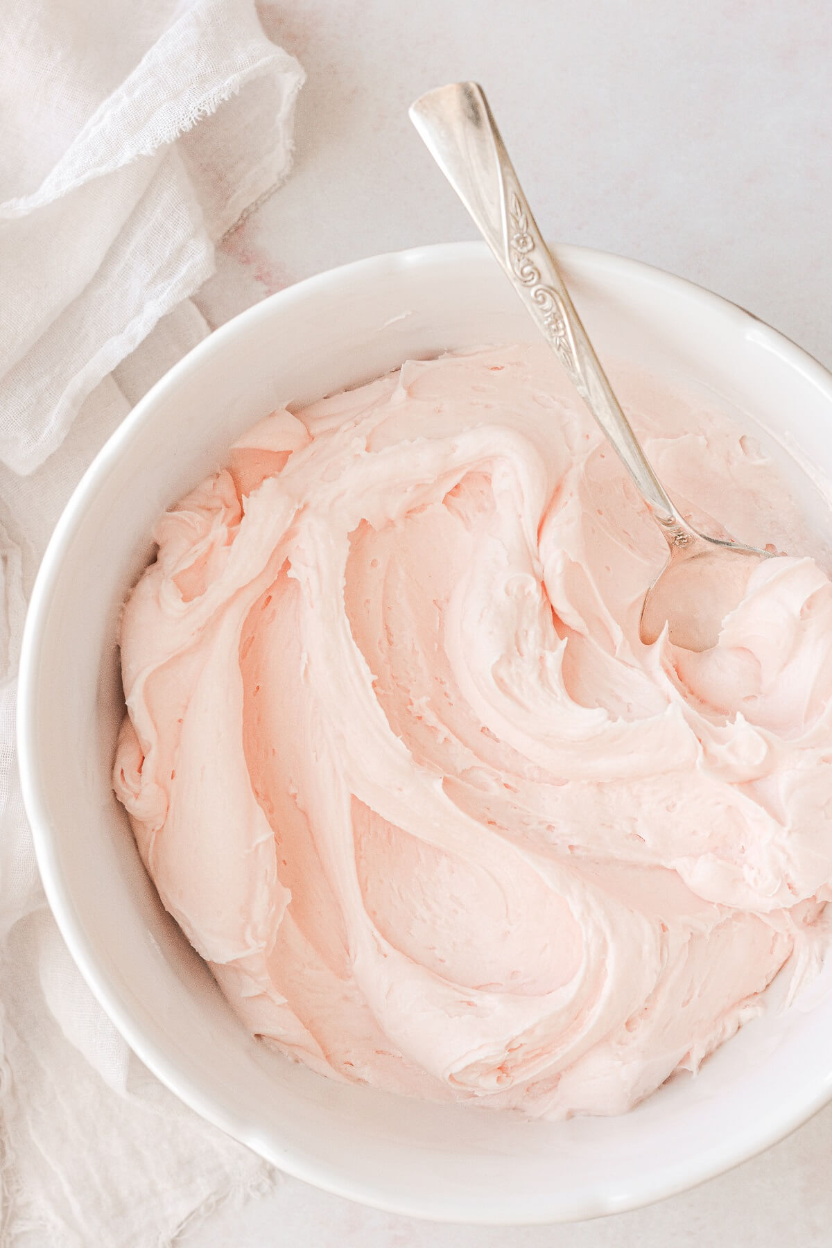 A bowl of pale pink buttercream.