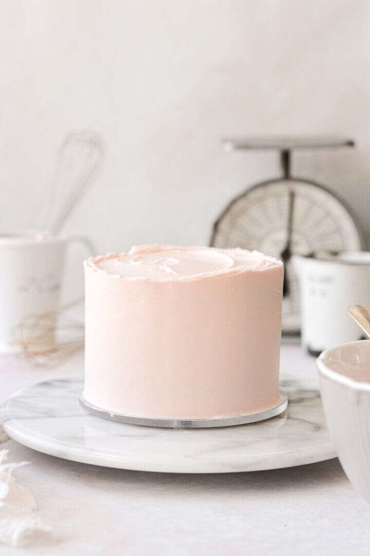 A cake with pale pink buttercream.