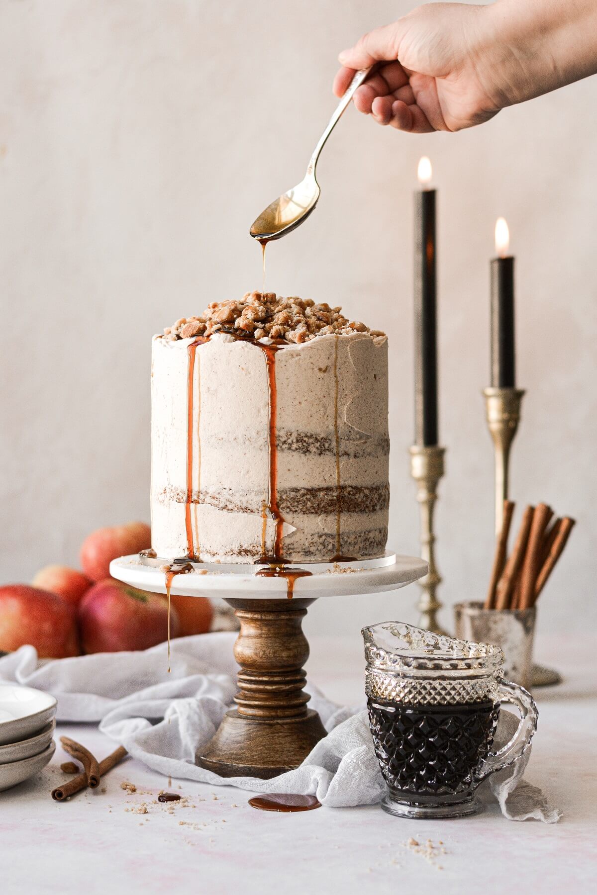 Apple cider concentrate drizzling over the top of an apple pie cake.