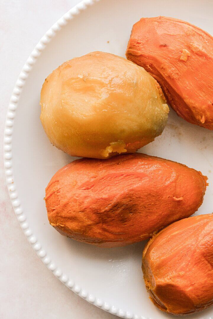 Roasted sweet potatoes without their peel, on a white plate.