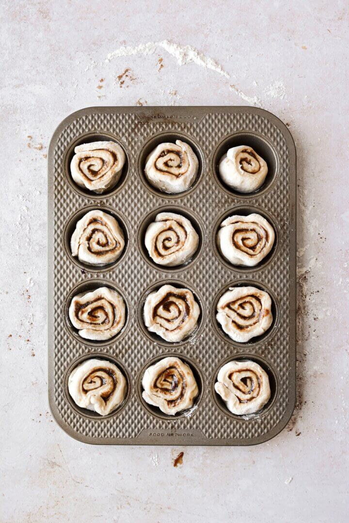 Unbaked cinnamon rolls in a muffin pan.