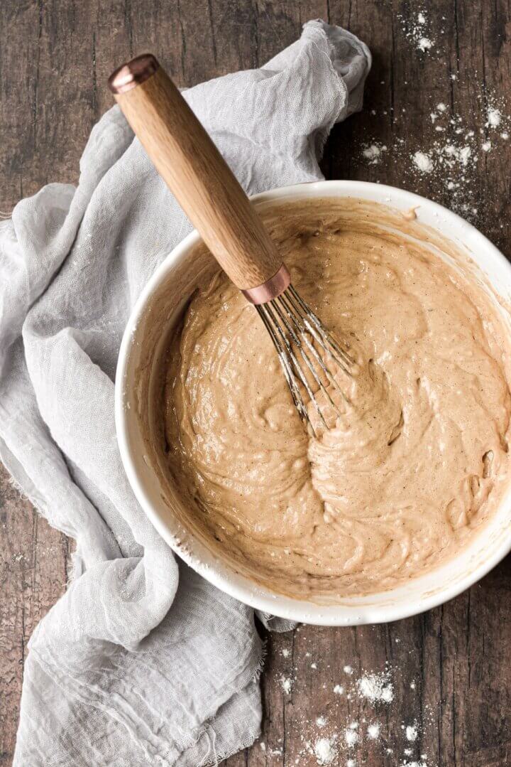 A bowl of pancake batter with a whisk.