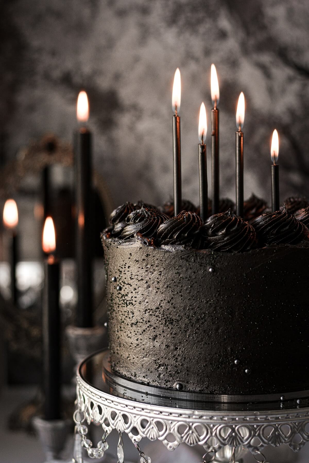 A black velvet cake topped with black candles.