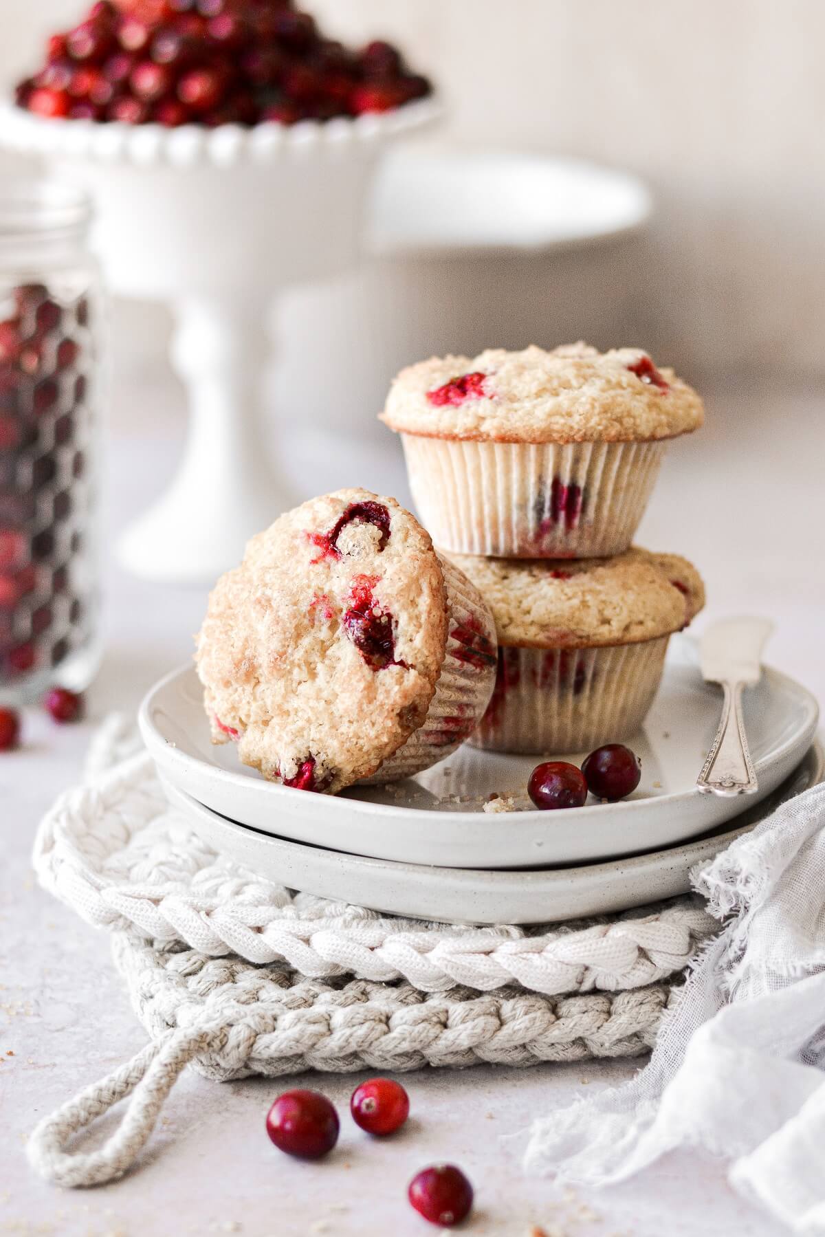 Cranberry orange muffins on a stack of plates.