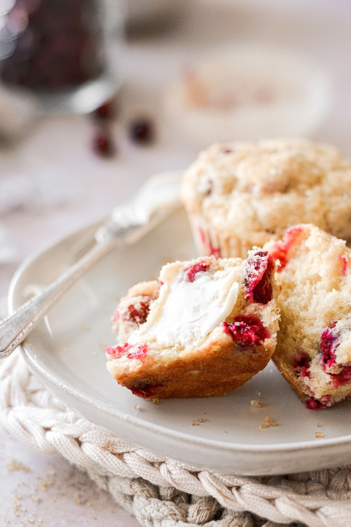 Cranberry orange muffins, one split and spread with butter.