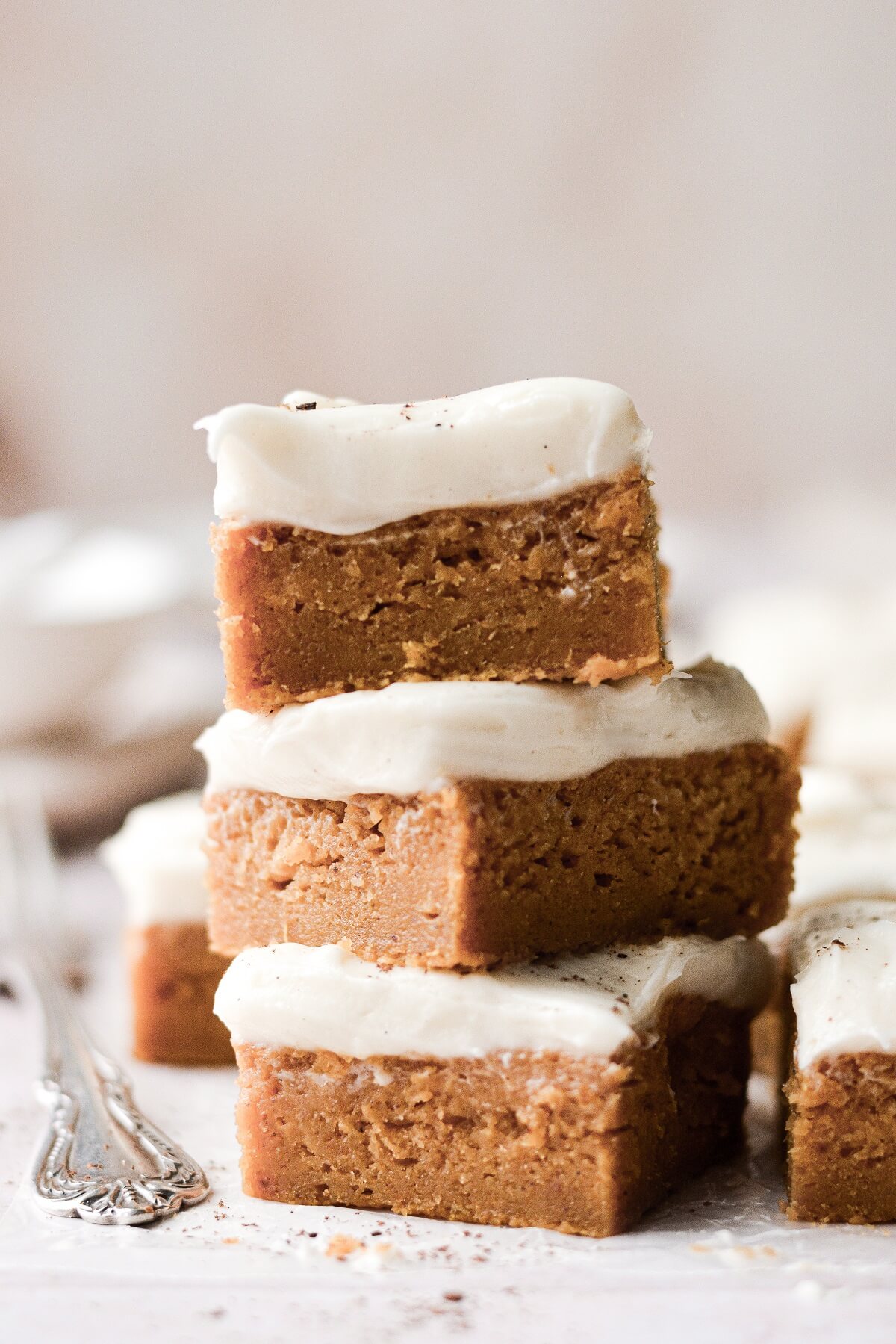 A stack of pumpkin bars with cream cheese frosting.