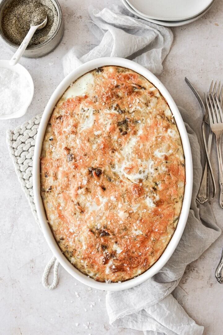 Sausage hashbrown breakfast casserole in a white oval baking dish.