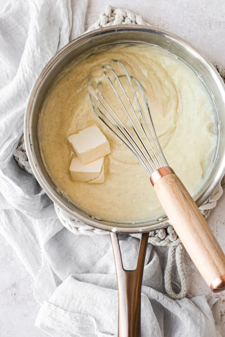 Butter being whisked into vanilla bean custard.