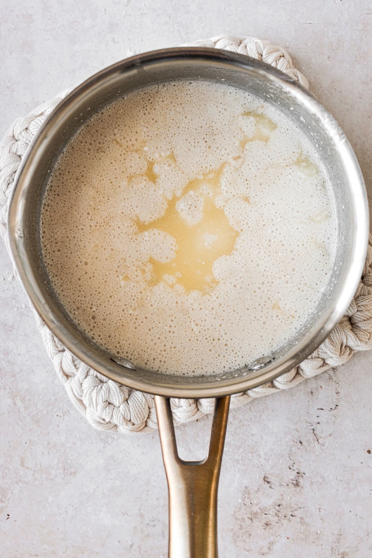 A saucepan of milk, butter and yeast.