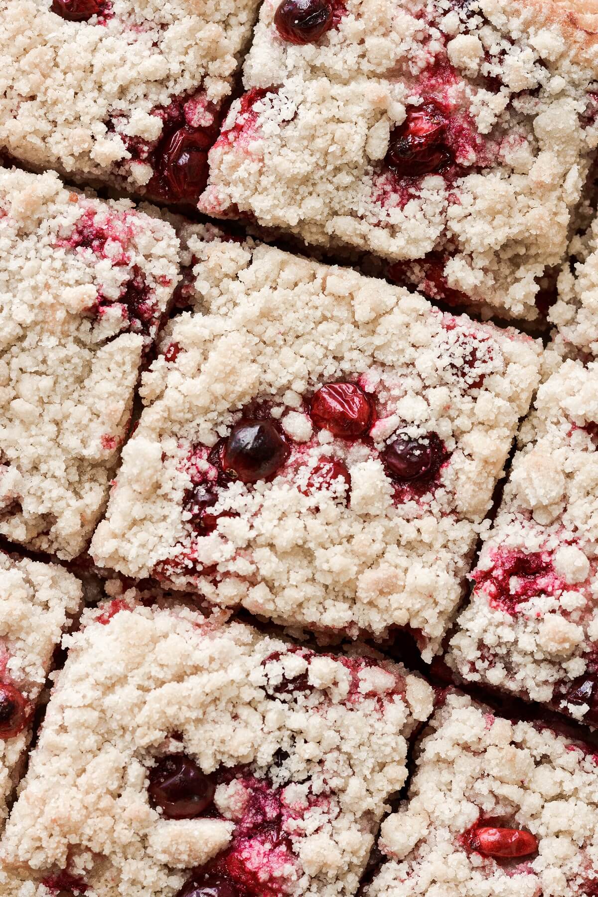 Squares of cranberry almond coffee cake with crumb topping.