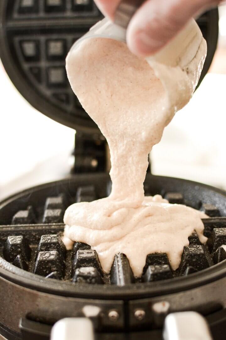 Waffle batter being poured into a waffle iron.