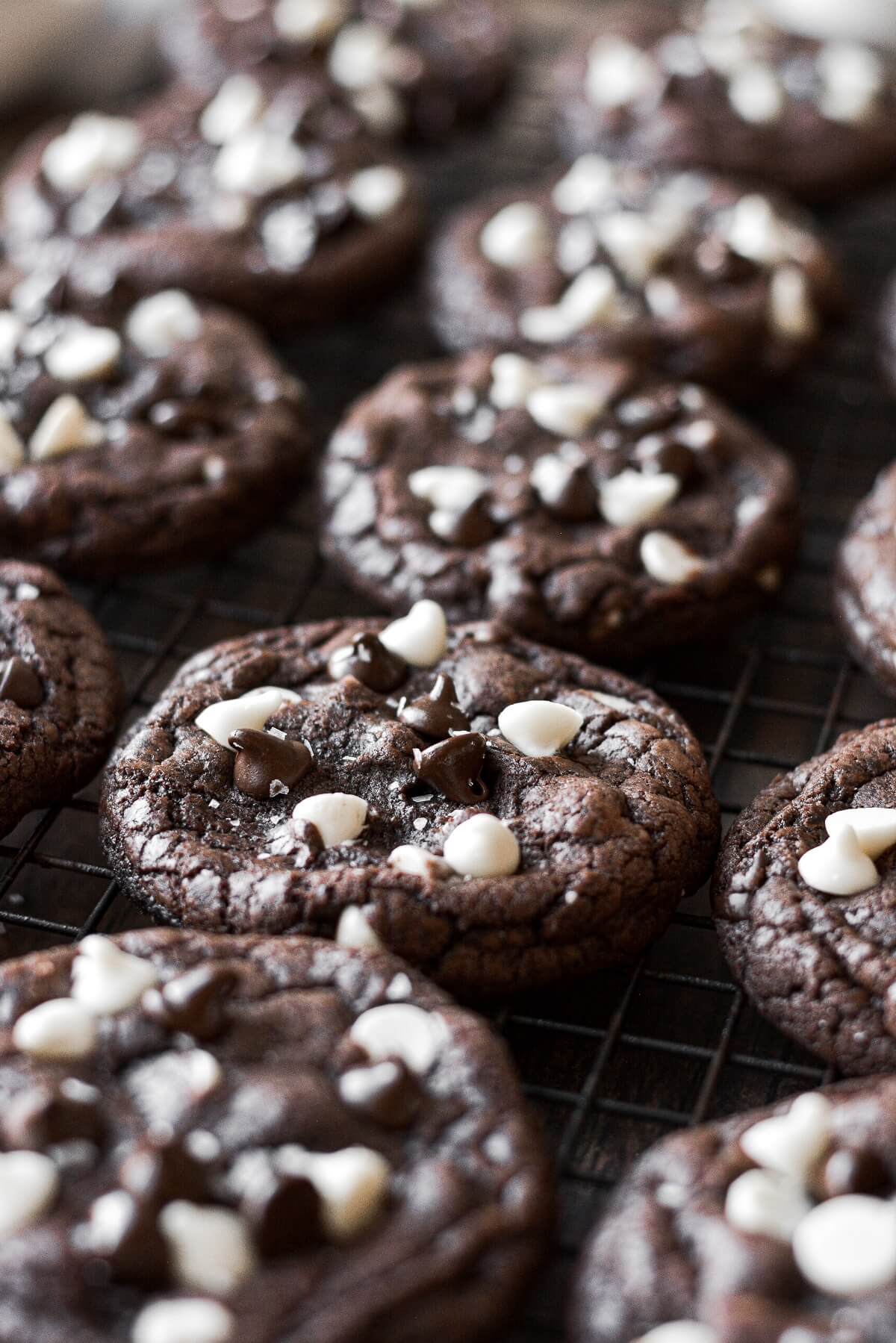 Chocolate white chocolate chip cookies arranged on a black cooling rack.