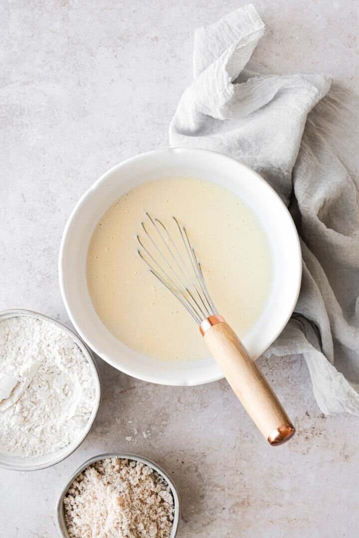 Coffee cake batter and a whisk in a bowl.