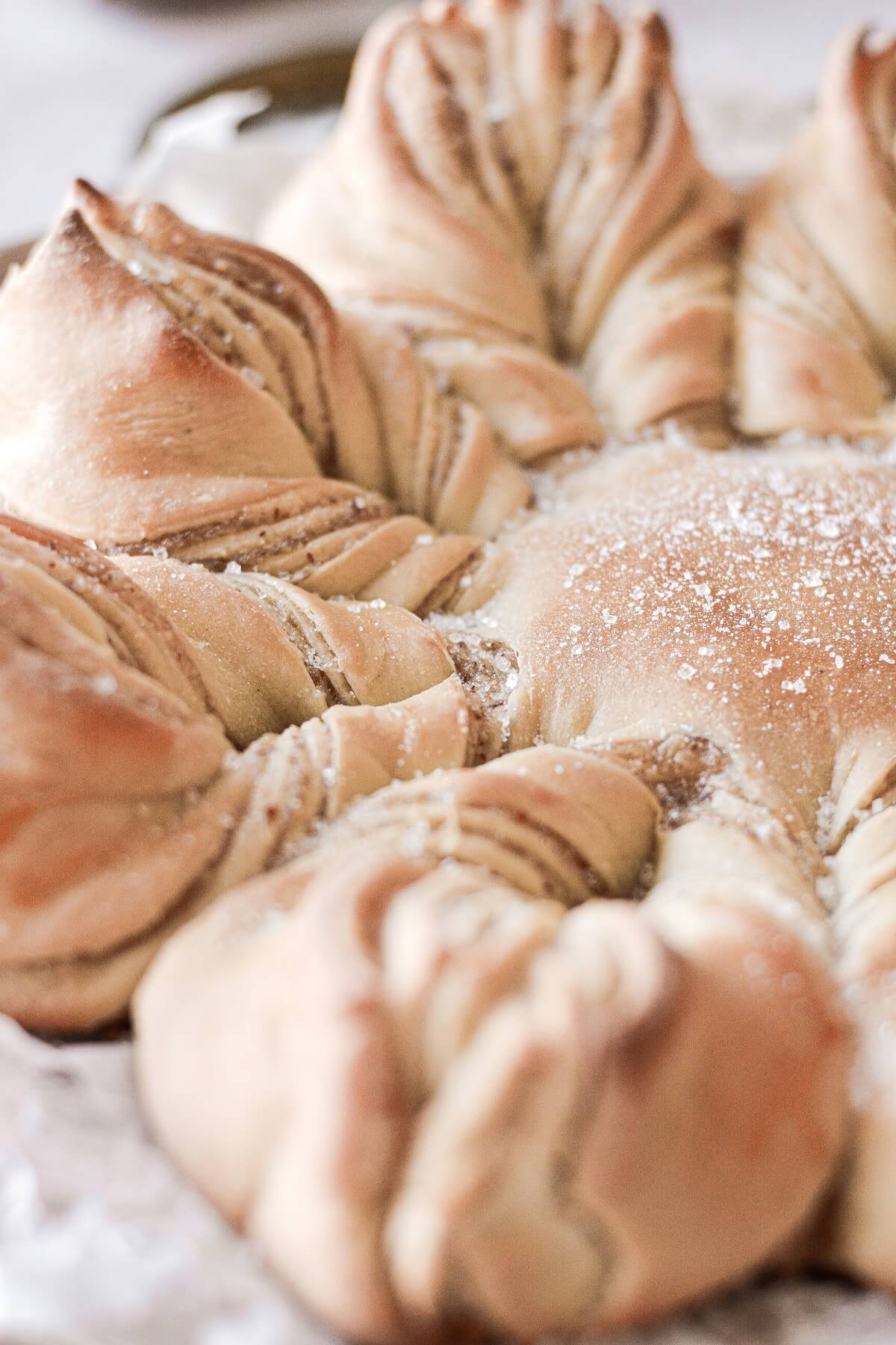 Closeup of sugar sprinkled onto cardamom almond star bread.