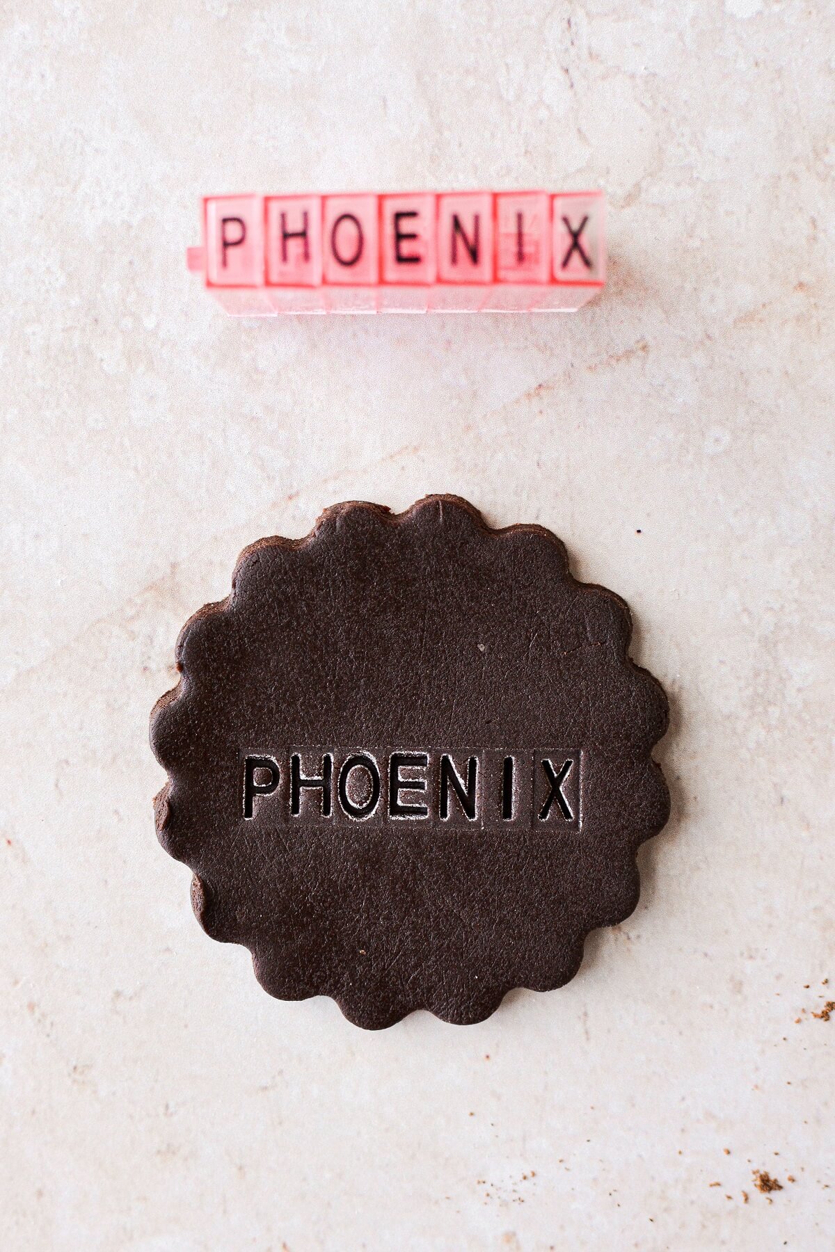 A chocolate place card cookie stamped with the name "Phoenix".