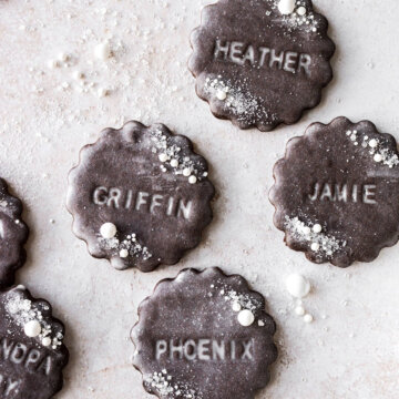 Chocolate cookies stamped with names and glazed with vanilla icing.