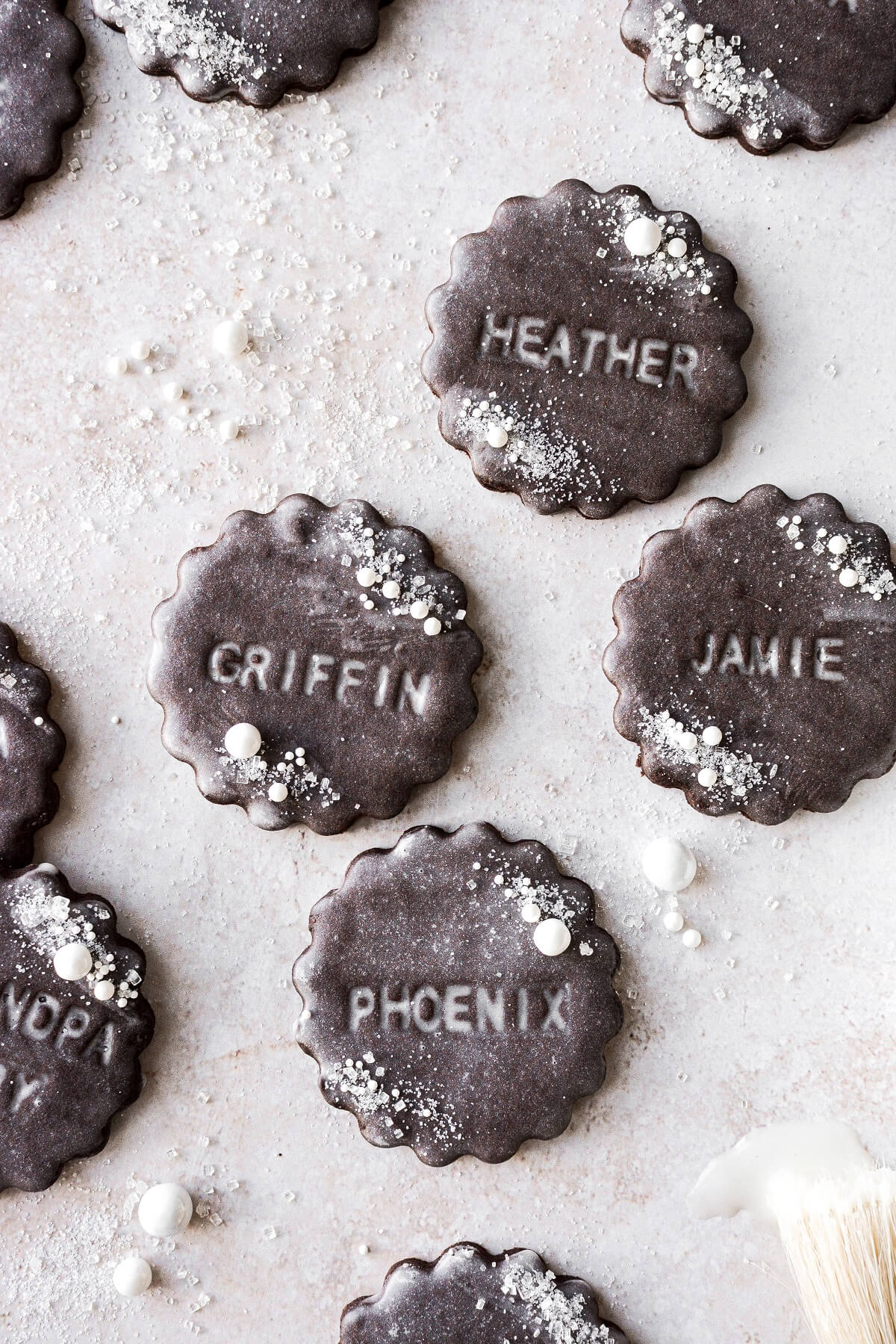Chocolate cookies stamped with names and glazed with vanilla icing.