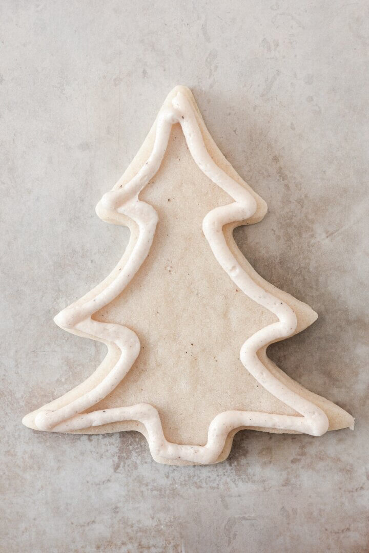 Buttercream piped in an outline on a Christmas tree cookie.