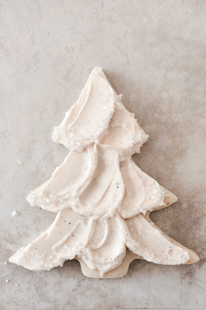Buttercream spread onto a Christmas tree cookie, and sprinkled with sparkling sugar.