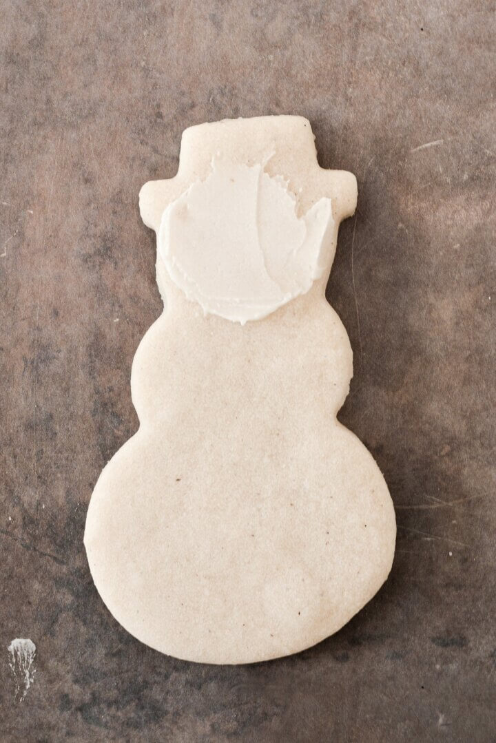 A snowman cookie spread with buttercream.