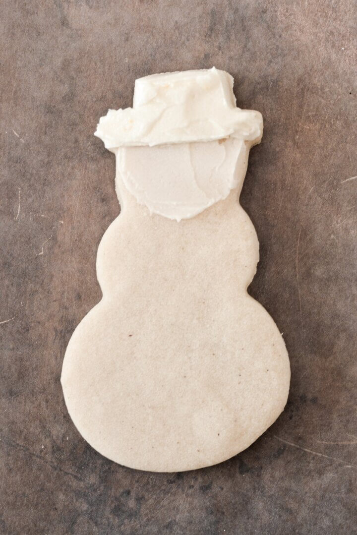 A snowman cookie spread with buttercream.