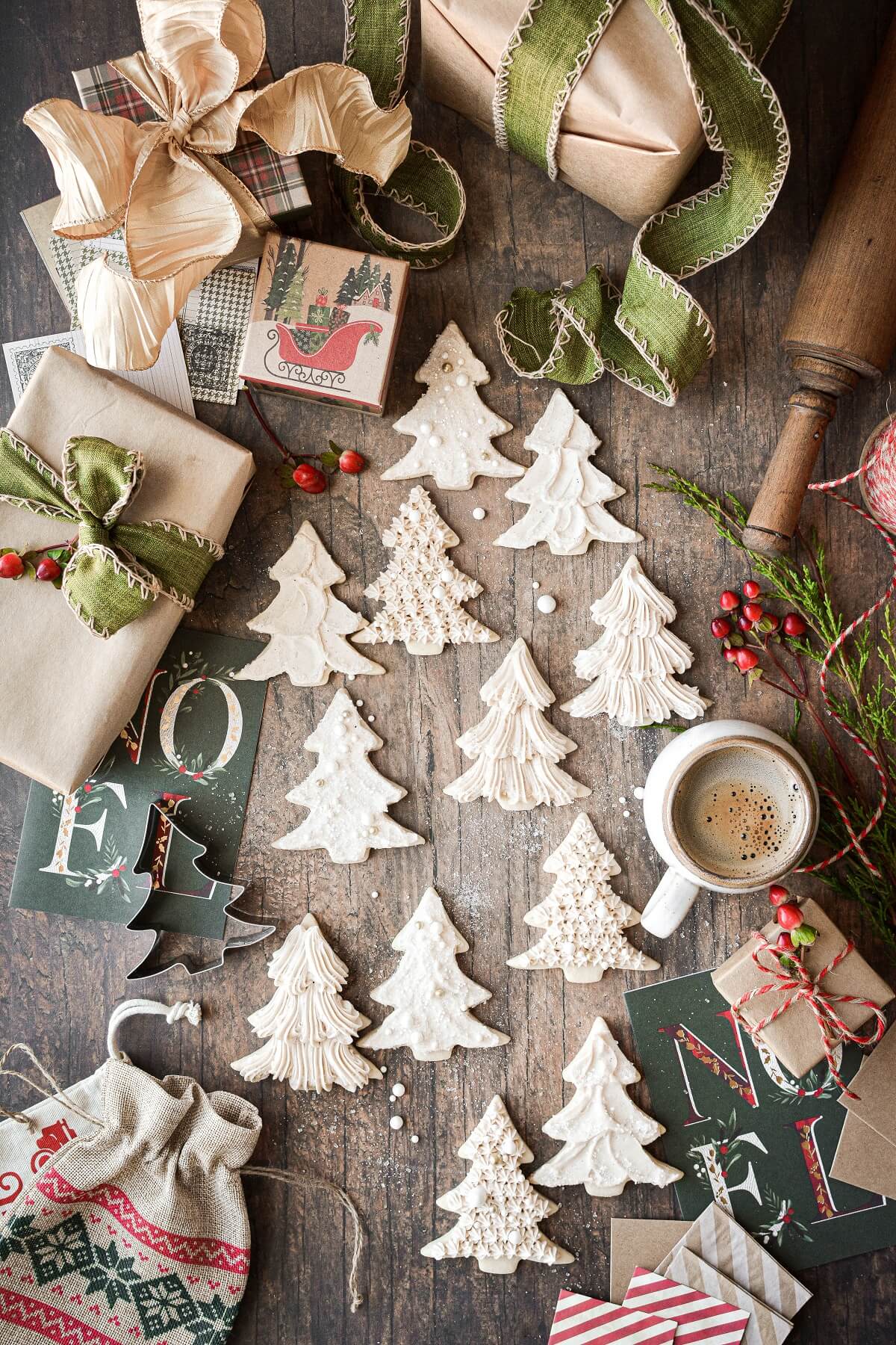 Christmas tree sugar cookies surrounded by presents and Christmas cards.