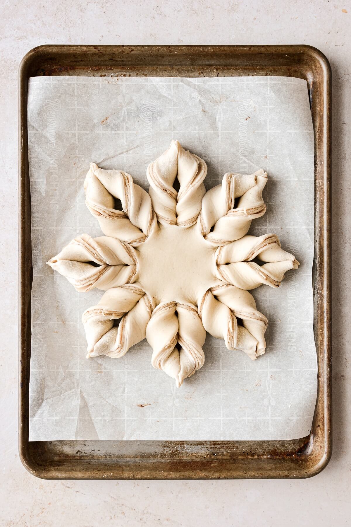 Cardamom almond star bread on a baking sheet, ready to be baked.