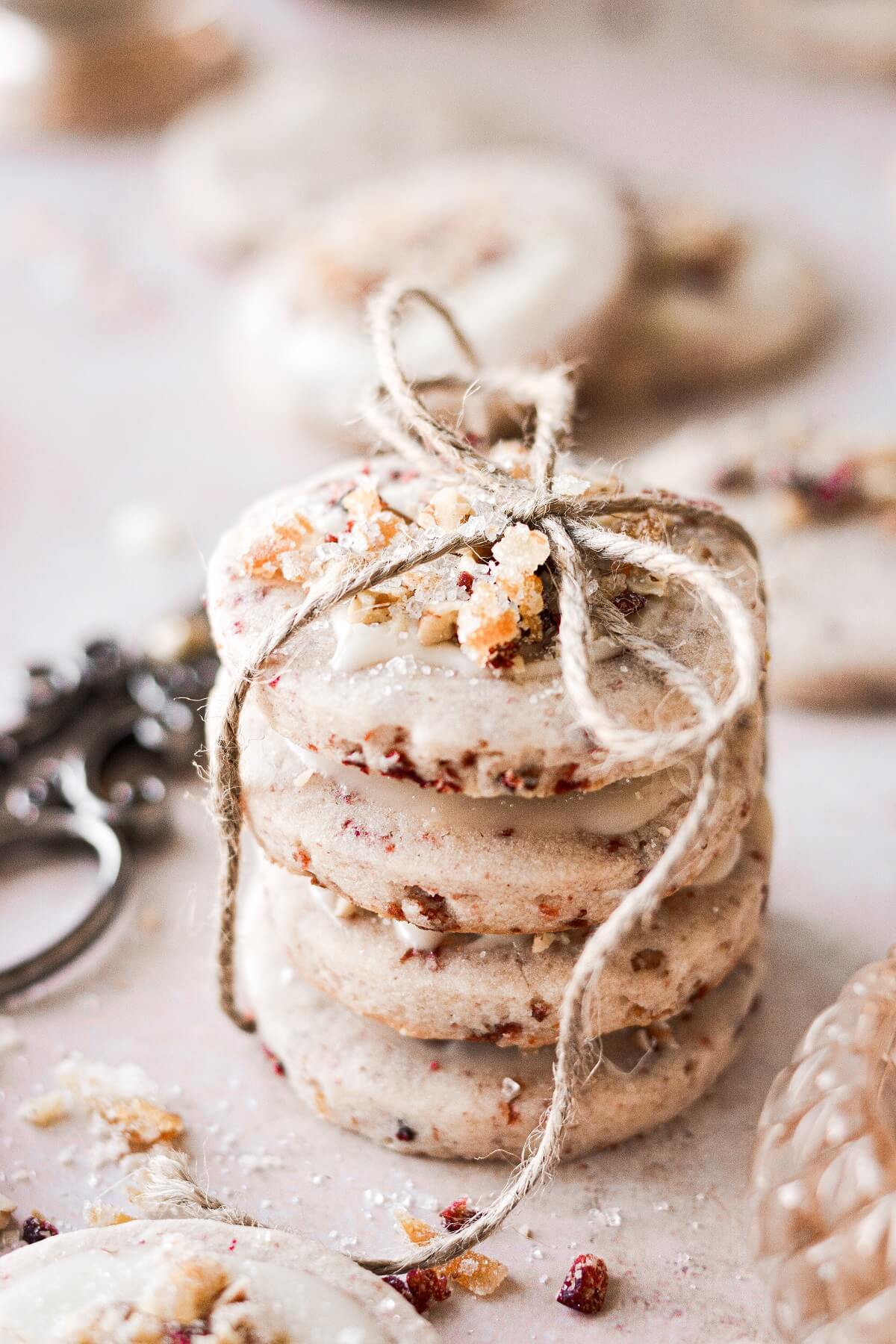 A stack of cranberry pecan shortbread cookies tied with twine.