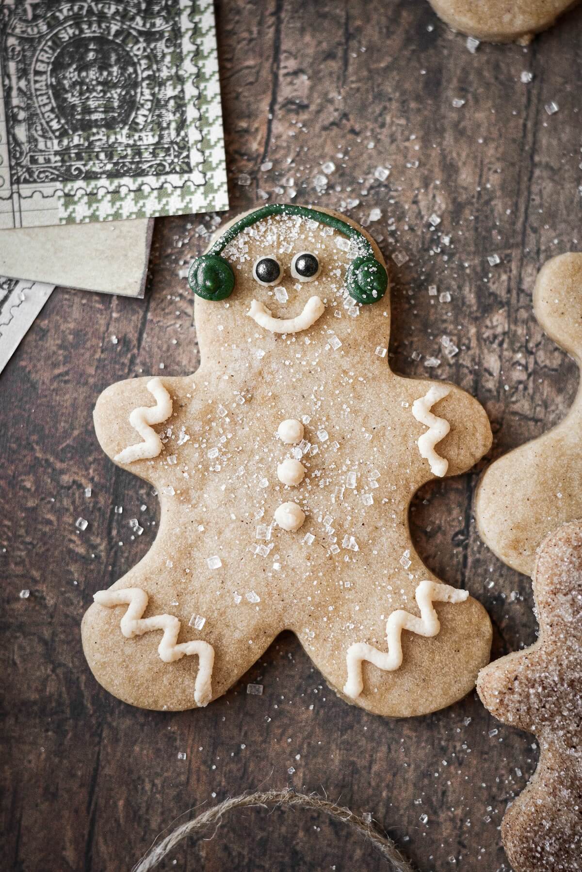 A gingerbread cookie decorated with green ear muffs.