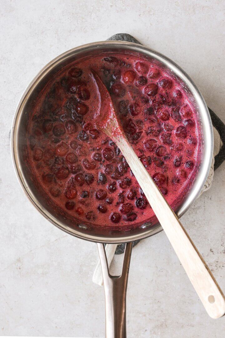 Homemade cranberry jelly simmering in a saucepan.