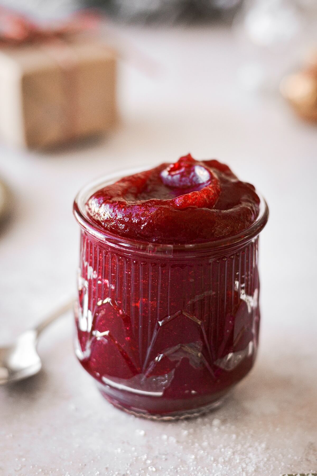 A glass jar filled with homemade cranberry jelly.
