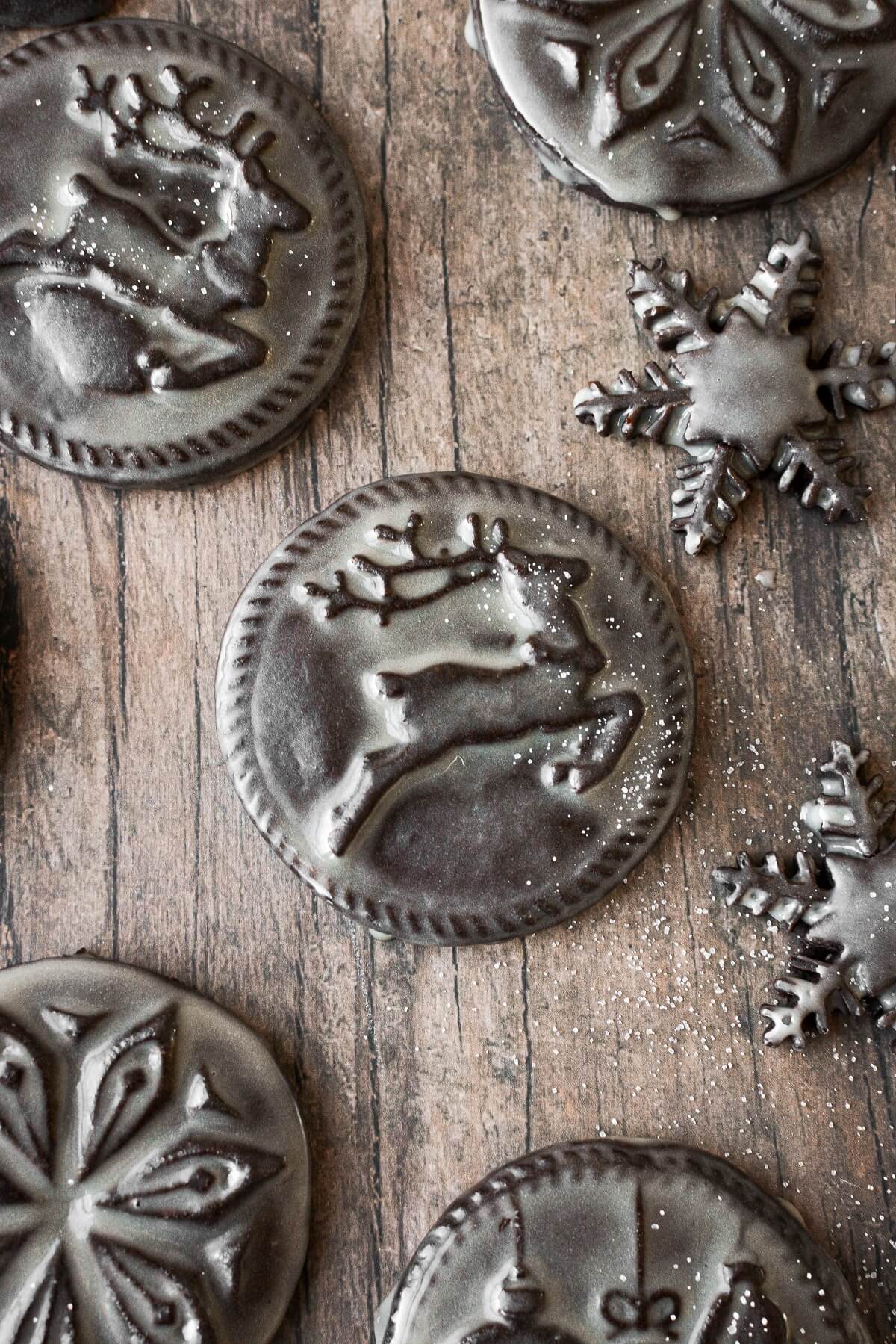 Chocolate shortbread cookies with Christmas designs stamped on them, glazed with icing.