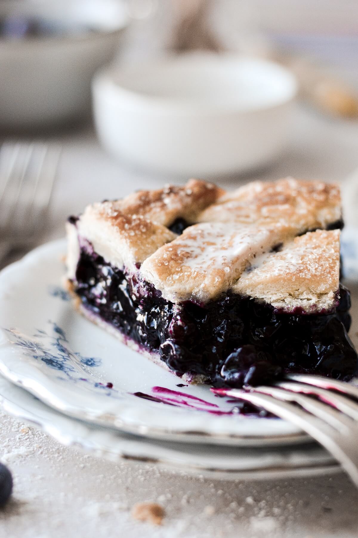 A slice of blueberry pie with one bite taken.