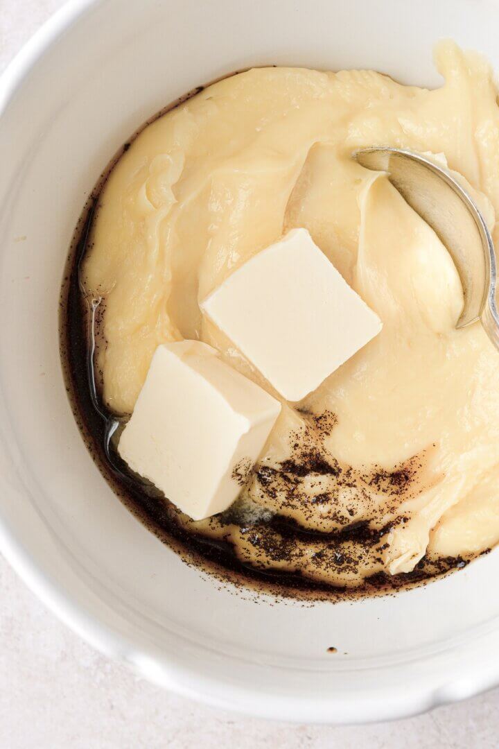 Butter and vanilla being stirred into vanilla bean custard.