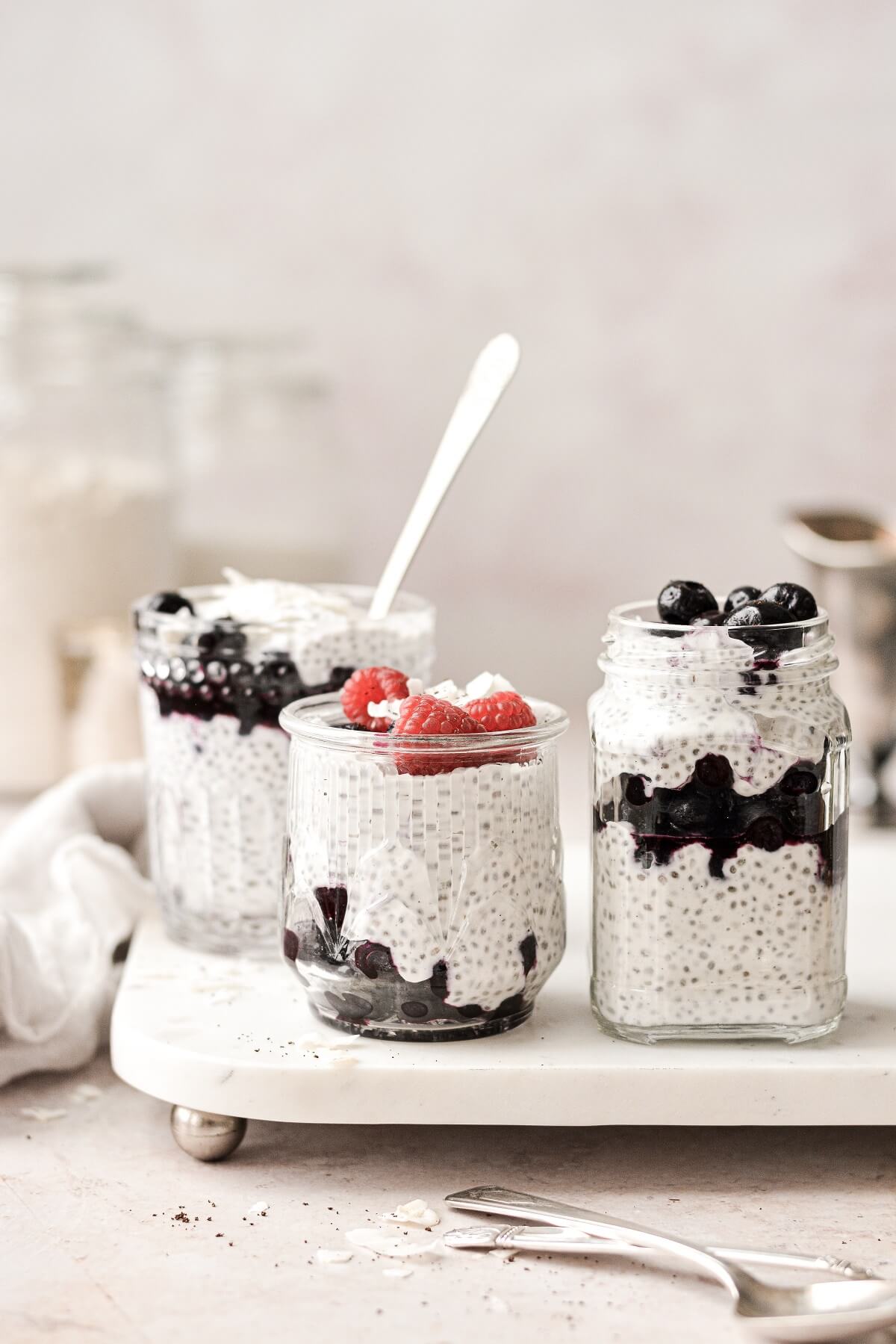 Coconut chia pudding parfaits in glass jars.