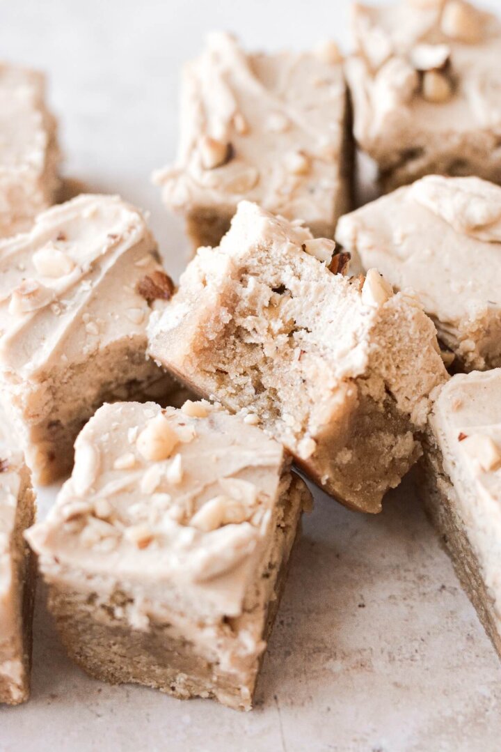 Frosted Hazelnut maple sugar cookie bars, one with a bite taken.