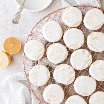 Iced lemon shortbread cookies on a gold cooling rack.